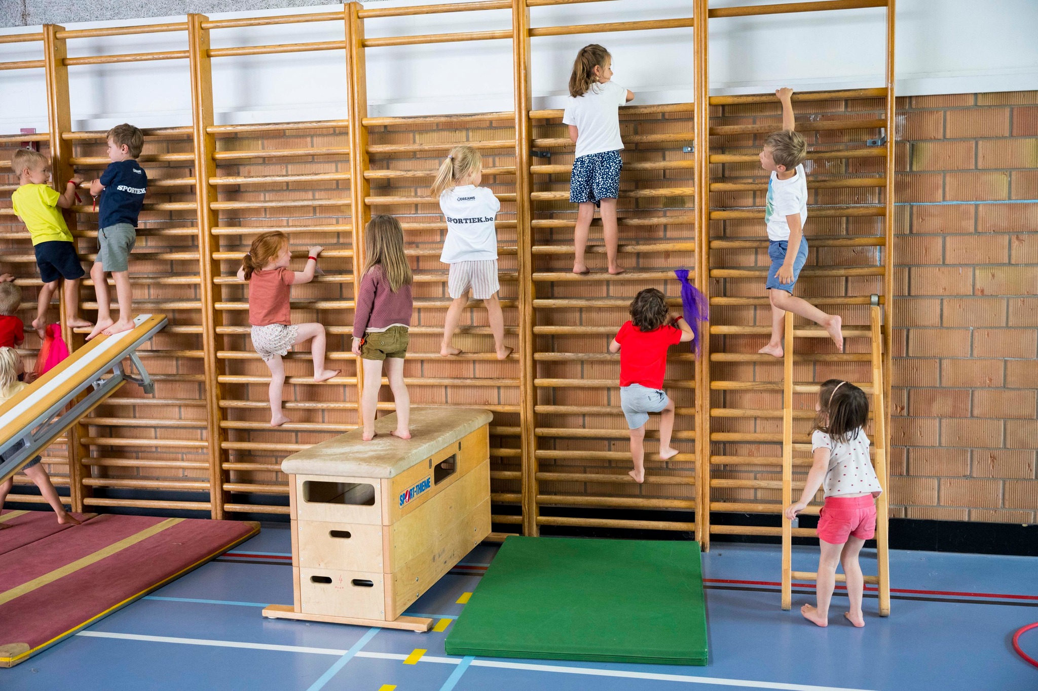 Kinderen op klimmuur en speeltoestellen